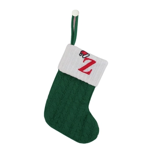 Close-up of green knitted Christmas stocking with white cuff and red embroidered letter Z