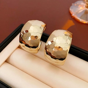 Minimalist thick C-shaped gold hoop earrings with hammered texture in a jewelry box