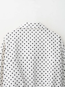 Détail du dos d'un chemisier blanc à pois avec col classique et structure d'empiècement