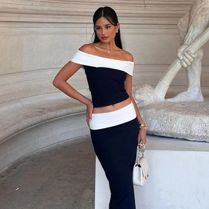 Detail of a chic black off-shoulder top featuring a contrast white lapel and waist cincher