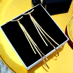 Elegant gold tassel earrings with long snake bone chains in a luxury jewelry box