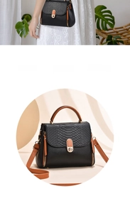 Detail of crocodile pattern flap on black crossbody bag with gold rotating lock