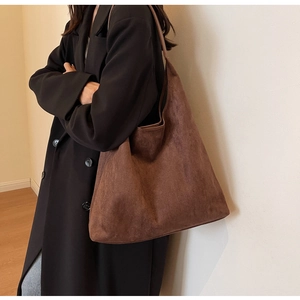 Brown faux suede tote bag shown on model with minimalist oversized commuter style