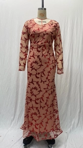 Detail of pink mesh fabric with intricate red sequin vine floral embroidery patterns