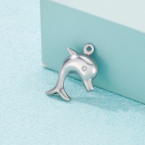 Polished silver stainless steel hollow dolphin pendant on a textured blue surface
