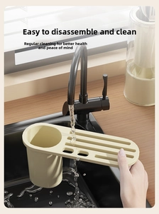 Detail view of cream kitchen organizer with drainage holes being rinsed under a faucet