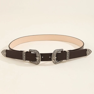 Detail of western vintage belt showing carved silver double buckles on dark brown leather