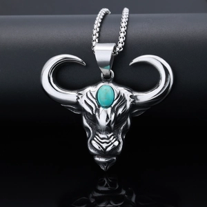Vue macro du pendentif tête de taureau argentée vintage avec incrustation de turquoise