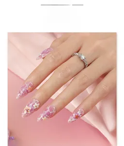 Détail de faux ongles en amande avec texture marbrée et motifs floraux d'été
