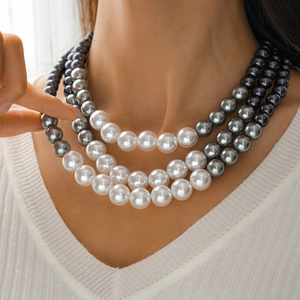 Detailed view of triple-layered pearl necklace with white and grey gradient beads on model