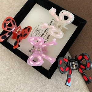 Set of four colorful acetate bow hair claws with knitted yarn accents and gold metal springs