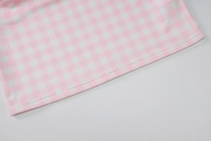 Détail de la texture du tissu vichy rose et blanc avec coutures doubles de précision