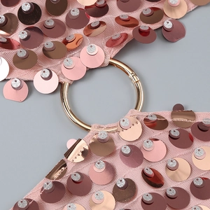 Détail macro du tissu en maille rose avec paillettes brillantes et boucle dorée