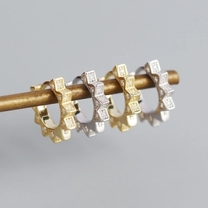 Macro shot of geometric starburst ear cuffs in gold and silver with micro-pave zircons