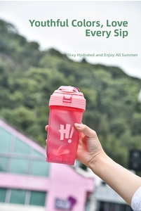 Detailed view of a pink plastic fitness shaker cup with a straw and H! lettering