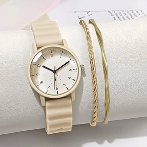 Close-up of beige wavy silicone strap watch paired with two gold-tone metal bracelets