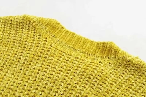 Detailed close-up of yellow chenille knit sweater featuring a ribbed crew neck design
