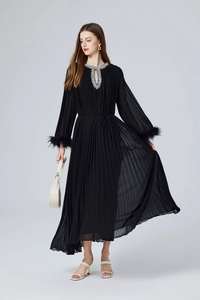 Détails de la robe plissée noire avec poignets en plumes et col orné de strass