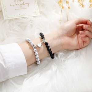 Close-up of magnetic heart clasp on natural stone couple bracelets set with gift card
