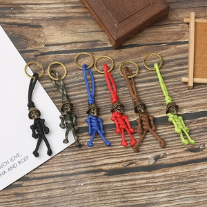 Set of six colorful paracord skull keychains with metal helmets on dark wood background