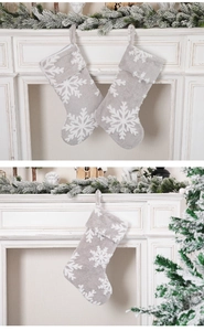 Gros plan sur chaussette de Noël en peluche grise avec flocon de neige jacquard blanc
