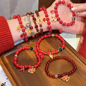 Detailansicht von roten Achat-Perlenarmbändern mit traditionellen chinesischen Glücksbringern.