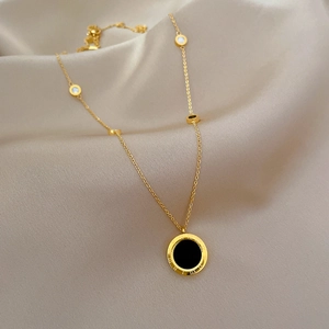 Elegant gold titanium necklace with Roman numerals pendant on beige silk background