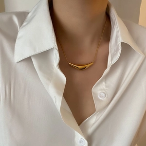 Collier minimaliste en or avec pendentif sourire et chaîne serpent porté par un mannequin