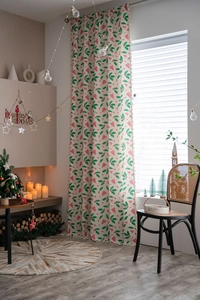 Detail of Christmas curtain featuring green holly leaves and red plaid hearts with pom-poms