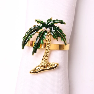 Close-up of golden coconut tree napkin ring with green enamel and pearl accents