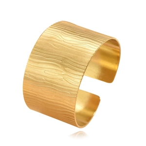 Vintage wide gold C-shaped open cuff bracelet with irregular hammered texture on white background
