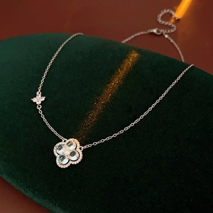 Détail du collier trèfle avec pierres bleu clair et diamants sur velours vert
