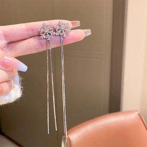 Détail des boucles d'oreilles flocon d'argent avec de longues franges et zircons brillants