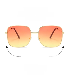 Detail of square gold metal frame sunglasses with orange gradient lenses on white background