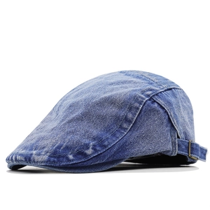 Detail of adjustable metal buckle and stitching on blue washed denim flat cap