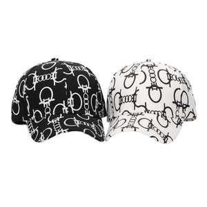 Detail view of two baseball caps with monogram print in black and white styles
