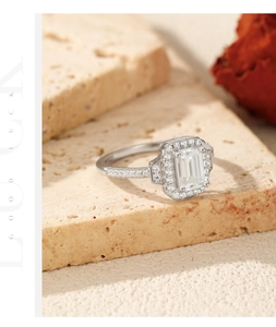 Close-up of emerald cut moissanite silver ring on a textured stone with dry flowers