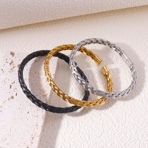 Three-piece set of woven stainless steel cable cuff bracelets in gold, silver, and black finishes
