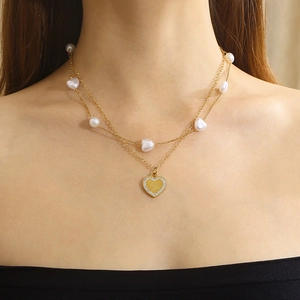 Golden double-layer necklace with pearls, heart pendant, and I love you engraving