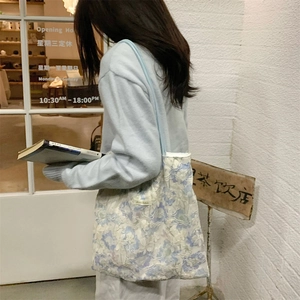 Detail of light blue floral lace tote bag with 3D flower embroidery and long shoulder strap