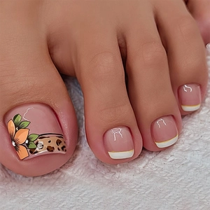 Detailed macro shot of orange floral and leopard print press-on toenails on white fur