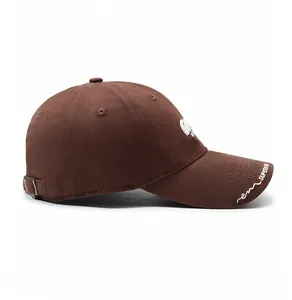 Side view of dark brown cotton baseball cap with white 3D embroidery and metal buckle