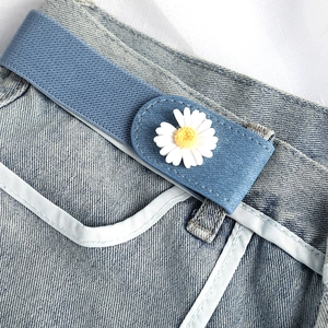 Elastic blue no-buckle belt with white daisy ornament on denim jeans waist