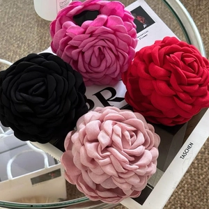 Eleganti fermagli per capelli a rosa in tessuto nero rosa e rosso su tavolo di vetro