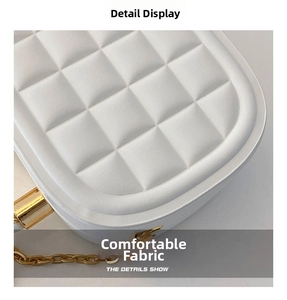 Detailed view of white quilted faux leather texture with elegant gold chain strap
