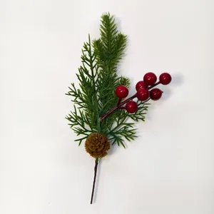 Close-up of artificial pine needles with a brown pine cone and red berries for Christmas decor