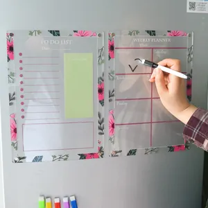 Clear acrylic weekly planner and to-do list with floral patterns on a gray fridge