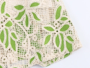 Gros plan détaillé du tissu en maille crochet beige et vert avec motif ajouré floral