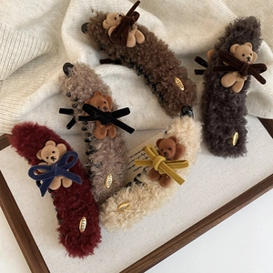 Close-up of five plush bear hair claws with velvet bows and lamb wool finish