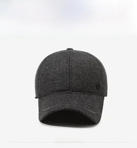 Detailed side view of the gray baseball cap featuring the circular metal emblem and brim stitching